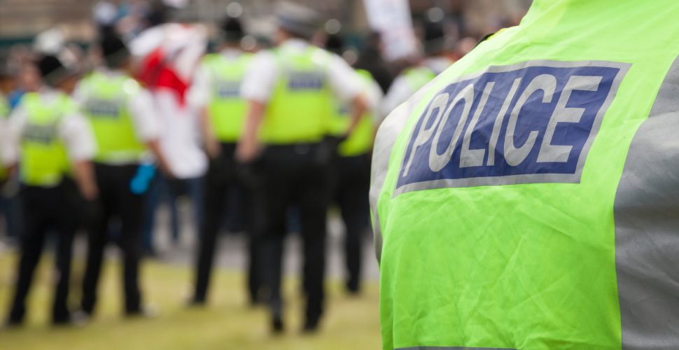 Close-up of police officers in high-visibility jackets at a public gathering, symbolising solidarity, public safety, and collective responsibility.