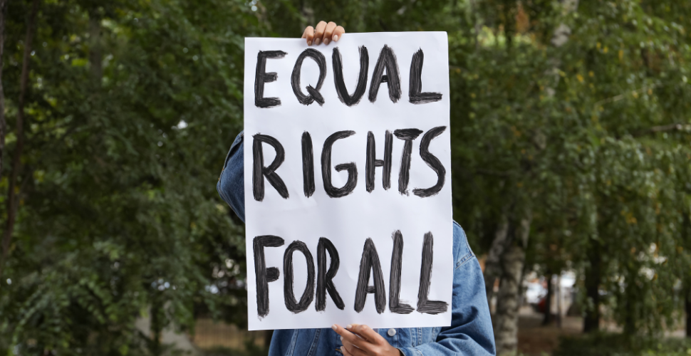 A person holds a sign reading “Equal Rights for All,” symbolising the call for racial equity and leadership in tackling racism within civil society.