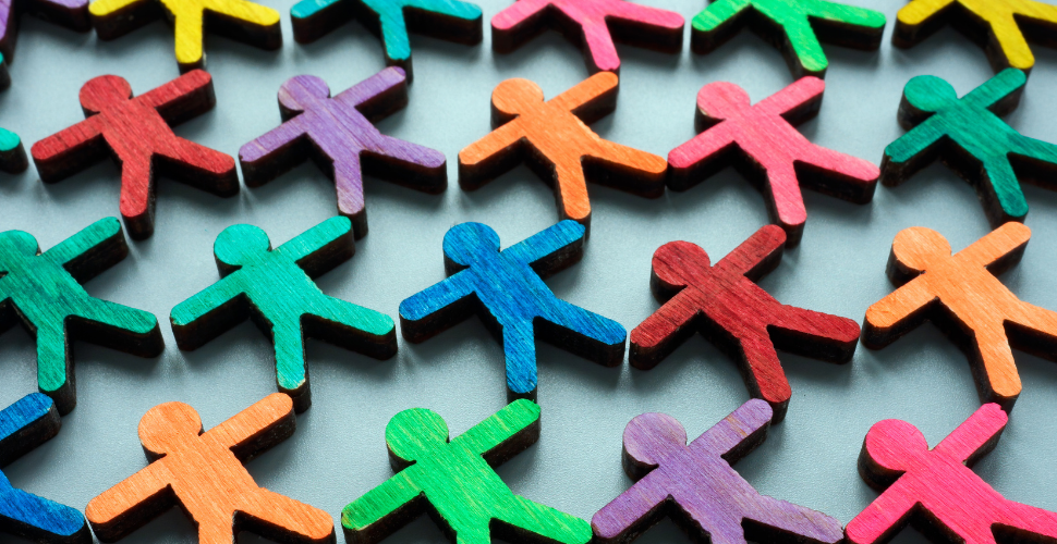 Rows of colourful wooden human figures arranged together, representing diversity, inclusion and equity in the workplace.